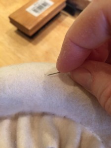 I used a pin to rough up wool fibers and scrape away the pin holes.